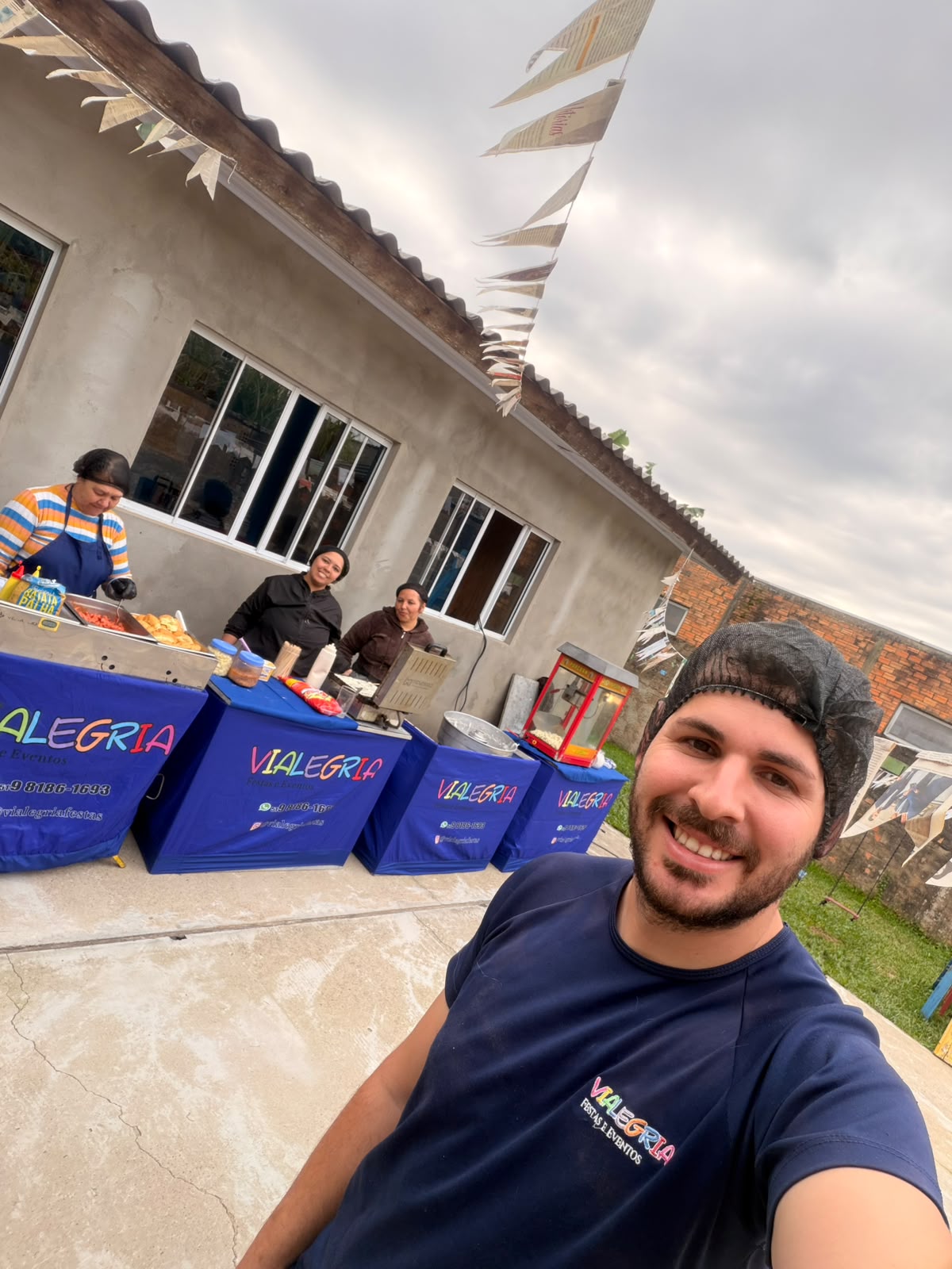 Equipe da Vialegria servindo buffet de festa com carrinho de pipoca